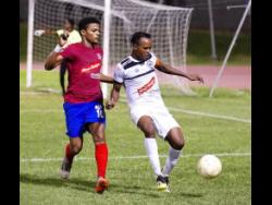 
Dunbeholden’s Adrian Williams and Cavalier’s Nicholas Hamilton (right) duel for                                     the ball in their Red Stripe Premier League match at the Stadium East Field on Sunday, December 16, 2018.