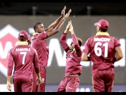 West Indies captain Jason Holder (second left) celebrates with teammates the dismissal of India’s Mahendra Singh Dhoni during the third one-day international cricket match between India and West Indies in Pune, India, Saturday, October 27, 2018.
