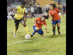 
Khadija Shaw (left) of Jamaica dribbles past Chile’s Cristiano Julio and Javiera Toro during their international friendly at the Montego Bay Sports Complex last night.