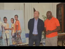 Josef Forstmayr (left), managing director of the Round Hill Hotel, admires the ‘Boys in Water’ art piece by artist Jeffrey Samuels (right) during an exhibition at the resort on Wednesday, March 20.