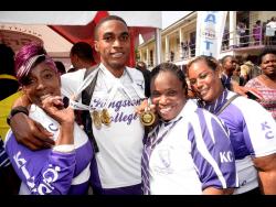 Kingston College (KC) standout Wayne Pinnock (second left) is surrounded by family members and fans during KC’s ISSA/GraceKennedy Boys and Girls’ Athletics Championships title celebrations at their North Street campus yesterday.