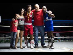Local amateur boxer Arnold Anderson (right) poses with his Panamanian counterpart Alejandro Diaz (third left), Panamanian ambassador to Jamaica, Alexis Sandoval, and members of his family at the Jamaica Boxing Board’s second Gloves For Guns event held at the Stanley Couch Gym in Kingston last Saturday.