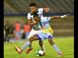 Ricardo Thomas (right) of Waterhouse fights to retain possession against Cavalier’s Alex Marshall in the  Red Stripe Premier League semi-final between Waterhouse and Cavalier at the National Stadium in Kingston last Monday.