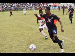 Ewan Barton of Faulkland FC attempting to dribble away from Falmouth United’s Shaquan Reid in their JFF/Charley’s JB Rum Super League first-leg semi-final at the Elleston Wakeland Centre in Falmouth, Trelawny, on Sunday. The game drew 1-1.