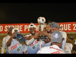 Members of the Portmore United team celebrate with the Red Stripe Premier League trophy after their 1-0 win over Waterhouse in the final at the National Stadium last night.