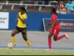 Reggae Girl Khadija Shaw (left) in action against Panama’s Maria Murilo at the National Stadium on Sunday.