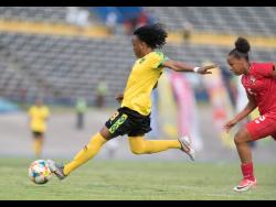 Jamaica’s Trudi Carter (left) drives a hard shot at goal ahead of Panama defender Katherine Castillo during their international friendly match at the National Stadium on Sunday.