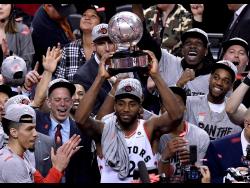 Toronto Raptors forward Kawhi Leonard (2) holds up the trophy after the team’s 100-94 win over the Milwaukee Bucks in Game 6 of the NBA basketball playoffs Eastern Conference finals on Saturday, May 25, 2019, in Toronto. The Raptors advanced to the NBA Finals. 
