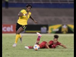 Reggae Girl Khadija ‘Bunny’ Shaw (left) dribbles to goal after beating Panama defender Yorima Pinzon during their international friendly match at the National Stadium on Sunday, May 19. 