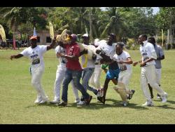Players from Arcadia cricket team lifted Man-of-the-Match Keromie Austin off the field after hitting the winning run in their four-wicket win over Cambridge in their SDC / Wray and Nephew National Community T20 Cricket competition at the Dumfries Oval in St James.