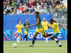 Khadija Shaw (left) dribbles the ball by Brazil midfielder Formiga yesterday in the FIFA Women’s World Cup  Group C encounter between Jamaica and Brazil.