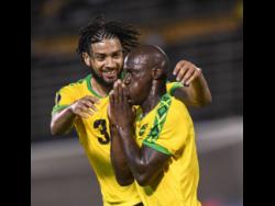 Michael Hector celebrates with  Dever Orgill after he scored his second goal as the Reggae Boyz beat Honduras 3-2 in their opening Gold Cup match at the National Stadium last night.