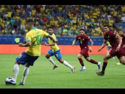 Brazil’s Roberto Firmino passes the ball to teammate Gabriel Jesus to score a goal that was disallowed by the referee during a Copa America Group A  match against Venezuela at the Arena Fonte Nova in Salvador, Brazil, on Tuesday.