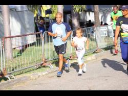 A father and a daughter participate in the Fathers and Children 3K run.