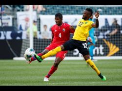 Panama’s Fidel Escobar (left) and Jamaica’s Junior Flemmings battle for the ball during the first half of a Concacaf Gold Cup match on Sunday in Philadelphia. Jamaica won 1-0 to progress to the semi-finals.
