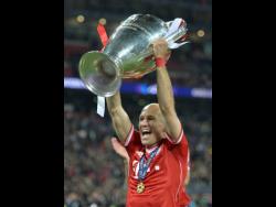 In this May 25, 2013 file photo, Bayern Munich’s Arjen Robben of the Netherlands lifts the trophy after winning the Champions League final against Borussia Dortmund. 