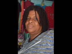 Sheryl Richardson recalls Chris Gayle’s contribution to the Rollington Town community at her place of business on Jackson Road yesterday.