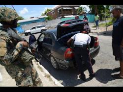Members of the Jamaica Defence Force and the Jamaica Constabulary Force doing spot checks in the Corporate Area.