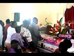 Relatives and well-wishers line up to view the body of Janice Cummings during her funeral at the Chatham Seventh-day Adventist Church in Blytheston, St James, on Sunday.