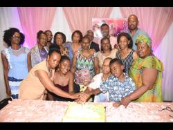 Family members and friends join Evelyn Stanley for the cutting of the cake.