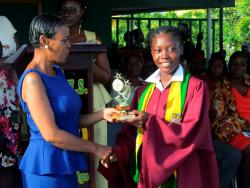 Valentina Wisdom (right) accepts an award from Francine Francis-Chin at her graduation ceremony last month.