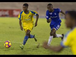 Clarendon College’s Lamar Walker (left), dribbles by Kingston College’s Trayvon Reid, during last season’s ISSA Olivier Shield clash at the National Stadium on Saturday, December 8, 2018. 
