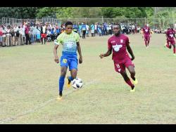 Ronaldo Webster of St Elizabeth Technical High school (left) attempts to dribble away from Newell High Schools defender Kristoff Thomas in a ISSA/WATA daCosta Cup first-round match last year.