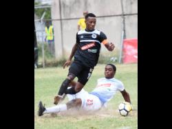 Emelio Russeau (right) of Portmore United puts in a sliding challenge on Chevone Marsh of Cavalier during a Red Stripe Premier League match on Sunday, February 10, 2019.