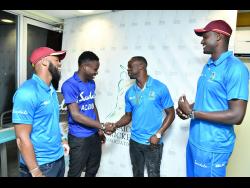 West Indies Test players John Campbell (left), Kemar Roach and Jason Holder (right) greet Jamaica Under-19 cricket captain Kirk McKenzie at Sabina Park on Wednesday.