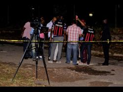Police personnel at the scene of yesterday’s triple murder in Temple Hall, St Andrew.
