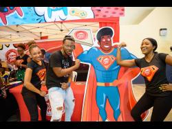 Social media personality Dutty Berry shows off his muscles with the Super Hut Girls and Super Hut Man at the Pizza Hut booth. 