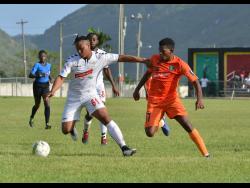UWI FC player Michael Heaven (left) tries to get away from Tivoli Gardens’ Stephen Barnett during their Red Stripe Premier League match at the UWI Mona Bowl on Sunday. 