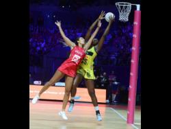Sunshine Girls captain Jhaniele Fowler (right) outstretches England Roses goalkeeper Geva Mentor to claim the ball, before scoring a goal during their Group G match of the Vitality Netball World Cup.