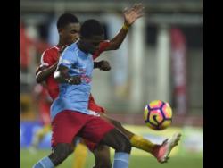 St George’s 
College’s Konato 
Campbell (right) shields 
the ball from Calvin 
Stephens of 
Cornwall 
College in a 
Champions Cup 
encounter last year.