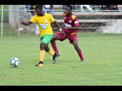 Jay Jamieson (left) of Petersfield High School attempting to dribble away from Port Antonio High School’s Errol Lane in their semi-final encounter of the ISSA/WATA Ben Francis Knockout Cup at the Juici Patties Park on Thursday, November 15, 2018.