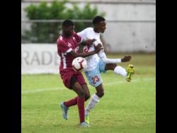 Eltham High School’s Dontae Brown (left) challenges St George’s College player Malique Dawes during their ISSA/Digicel Manning Cup encounter at Winchester Park on Monday. 