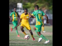 Clive Beckford of Charlie Smith (left) goes on the attack against Vindiesel Isaacs of Kingston High school in their ISSA/Digicel Manning Cup fixture played at Breezy Castle on September 14.