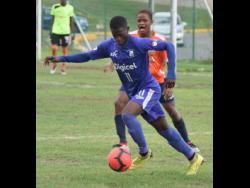 Kingston College’s Ronaldo Robinson (front) gets by Dunoon Technical’s Quala Rose during their ISSA/Digicel Manning Cup match at the Breezy Castle Field in downtown Kingston. Kingston College were leading 2-0 when the referee called a halt to the match in the 55th minute because of lightning in the area, on Tuesday, September 17.