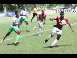 Chantomoi Taylor (right) of St George’s College getting away from Norman Manley High’s Rashawn Streete during an ISSA/Digicel Manning Cup match at Winchester Park yesterday. St George’s won 4-0. 