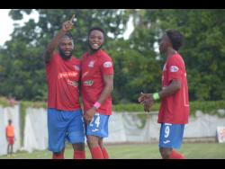 Dumbeholden’s goalscorer Dean Andre Thomas (centre) celebrates with teammates Andre McFarlane (left)  and Demario Phillips after finding the back of the net against UWI FC on Sunday.