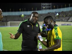 Jamaica’s coach Theodore Whitmore talks with Kemar Lawerence after the Reggae Boyz played The Cayman Islands at the National Stadium on September 9, 2018.