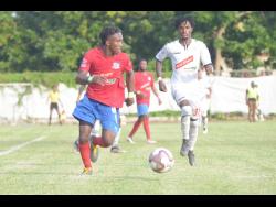 Dunbeholden forward Demario Phillips (left) dribbles as UWI defender Damano Solomon tries to close him down during their Red Stripe Premier League fixture at the Royal Lakes field in St Catherine on October 27.