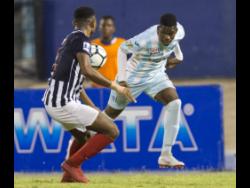 Chantomoi Taylor (right) of St George’s College tries to go past  Nathan Hunter of Jamaica College in the semi-final of the Manning Cup in 2018.