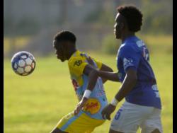  Andre Fletcher (left) of Waterhouse FC shields the ball from Vere United defender Ray Campbell during their Red Stripe Premier League encounter at Drewsland on September 12, 2019.