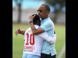 St George’s College’s player Nathanniel Campbell embraces his coach Neville Bell during a Manning Cup match at Winchester Park on September 9, 2019.
