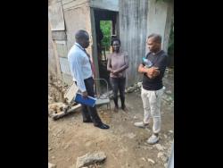 Contributed Photos
Constable Anderson (left) and Sargeant Christopher Ward of the Annotto Bay Police Station in St Mary speak to Karen Samuels about rebuilding her home.