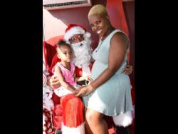 Ian Allen/Photograper
Santa Clause turned up in Kingston recently. He met several persons, including Dejonae Grant (left) and Sharyl Coke. Santa Clause was part of the Coca-Cola Christmas Truck Tour that stopped at St William Grant Park in Kingston.