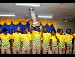 Members of the 2019 daCosta Cup title-winning team hoist the trophy during celebratory ceremony at the school yesterday. 