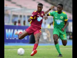 Rushan Parkinson of Dinthill (left) lines up to take a shot, while under pressure from Excelsior’s Junior Parker in the ISSA Champions Cup fixture held at the National Stadium on November 1.