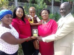 Cory-Ann Palmer (centre) shows off the medal she received for her bravery. Sharing the moment are (from left) her aunt, Stacy-Ann Brown; Shamara Brissett-Gordon, education officer and QEC-36 convenor; Judith Moore, education officer and QEC-36 co-convenor; and David Smalling, chairman of Albion Primary and Junior High School.
